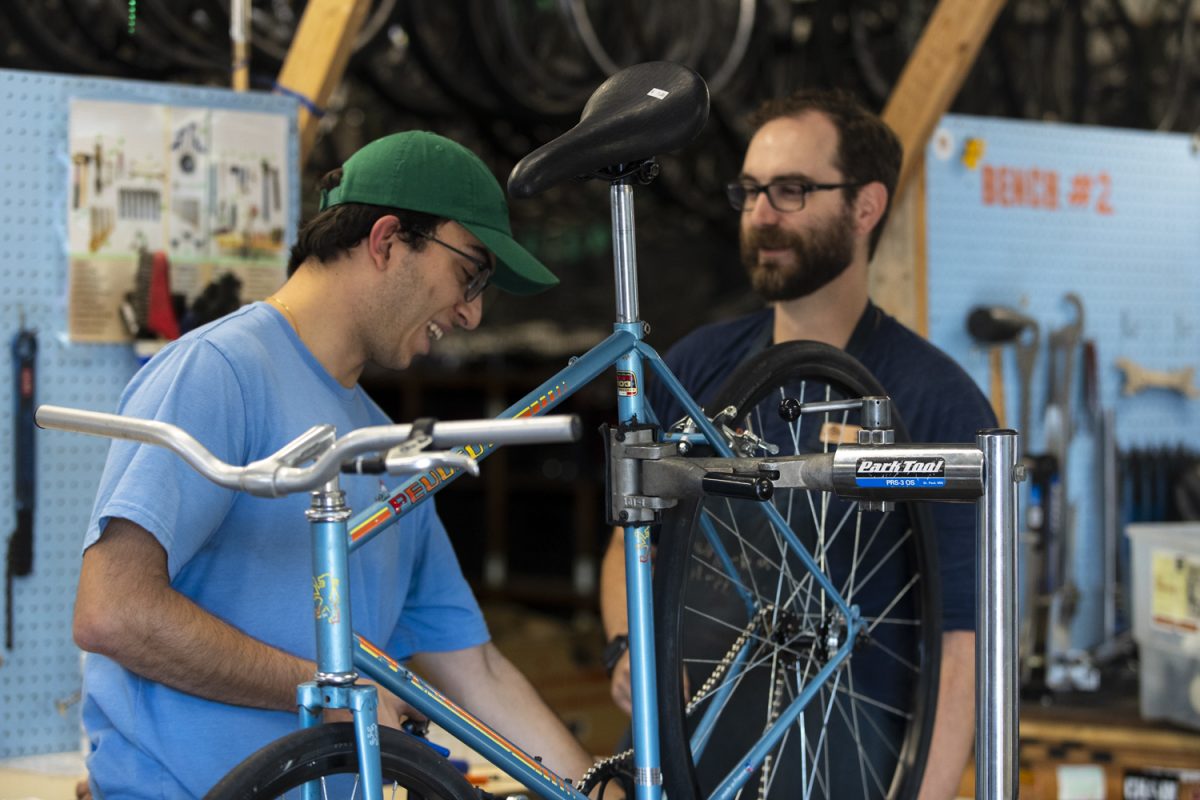 Lead Mechanic Drew Boss (left) helps a community member fix a bicycle at the Iowa City Bike Library on Friday, Oct. 4, 2024. The organization serves as a city resilience hub where individuals can access information and support in the case of an emergency event.