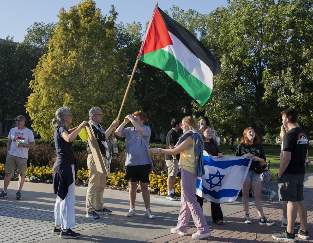 Pro-Palestine protesters interact with pro-Israel protesters during an International day of action protest by Iowans for Palestine at the Pentacrest in Iowa City on Saturday, Oct. 5, 2024. During the protest, speakers led chants, told personal stories, and held up signs.