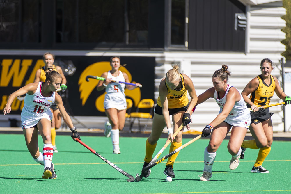 Maryland players attempt to get the ball from Iowa  midfielder Dionne Van Aaslsum during a field hockey game between No. 10 Iowa and No. 5 Maryland at Grant Field in Iowa City on Oct. 6. The Terrapins defeated the Hawkeyes 5-0.