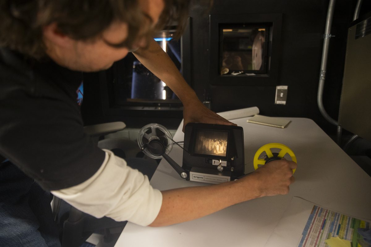 Head Projectionist and Facilities Director Ross Meyer demonstrates how to use an 8mm film editor inside the projection room of the FilmScene theater at The Chauncey on Oct. 9. To preserve film history, Meyer and other projectionists at FilmScene take time to inspect and transport film with caution and care.