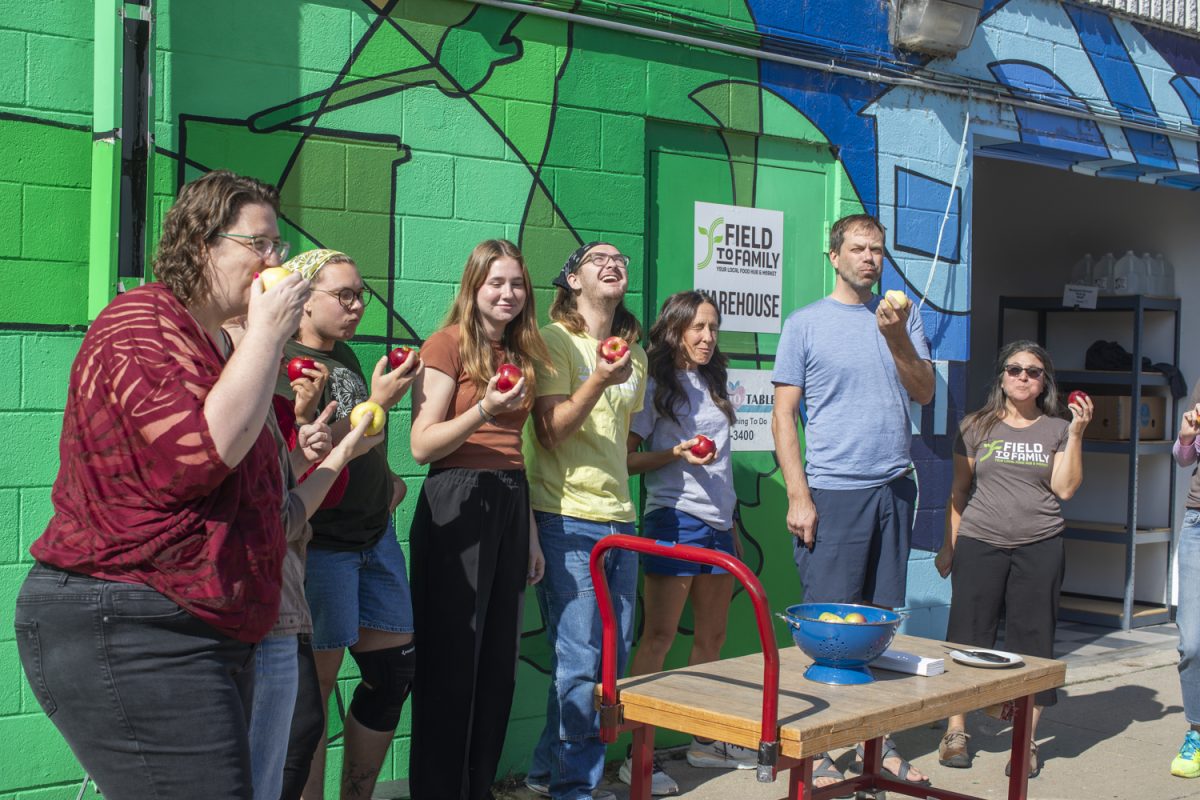 Teams from Field to Family and Table to Table bite into local apples from Buffalo Ridge Orchard during The Great Apple Crunch in Iowa City on Wednesday, Oct 9, 2024. The nationwide event celebrated local food purchases.