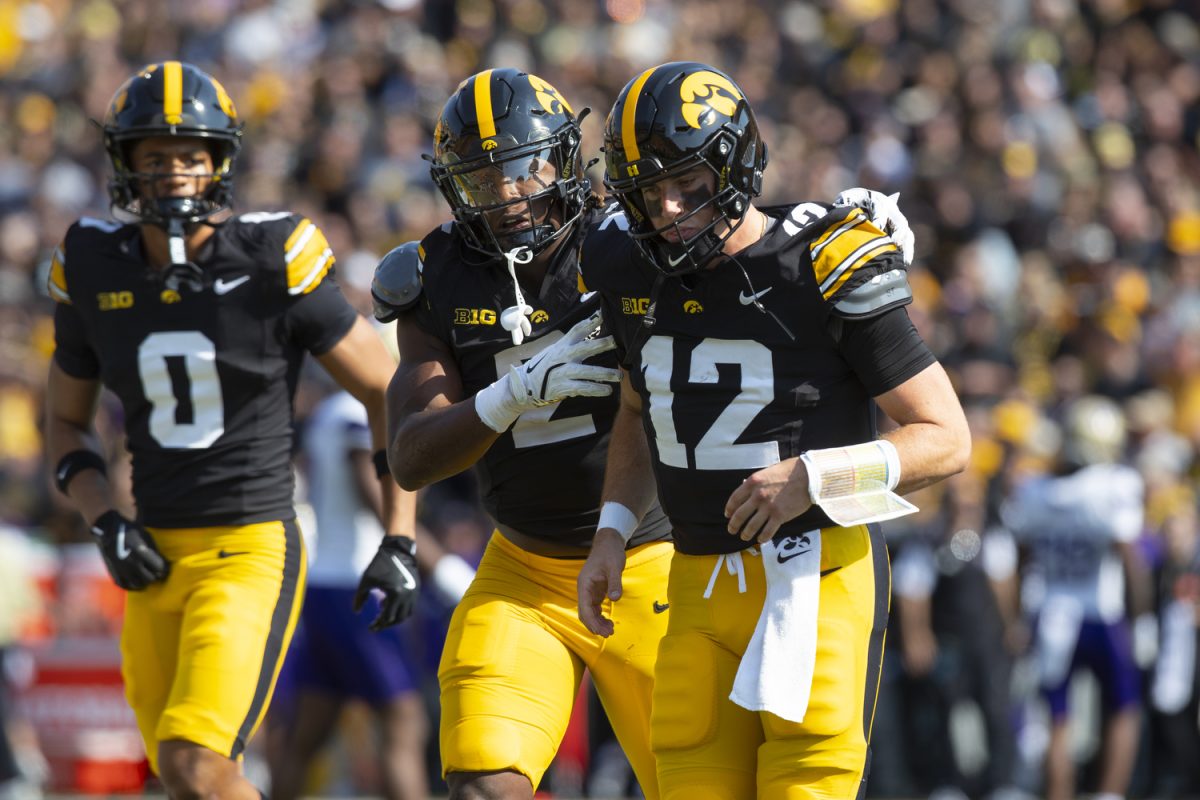 Iowa running back Kaleb Johnson talks to Iowa quarterback Cade McNamara after a call against Iowa during a football game between Washington and Iowa at Kinnick Stadium in Iowa City on Saturday, Oct. 12, 2024. The Hawkeyes defeated the Huskies, 40-16. (Emma Calabro/The Daily Iowan)