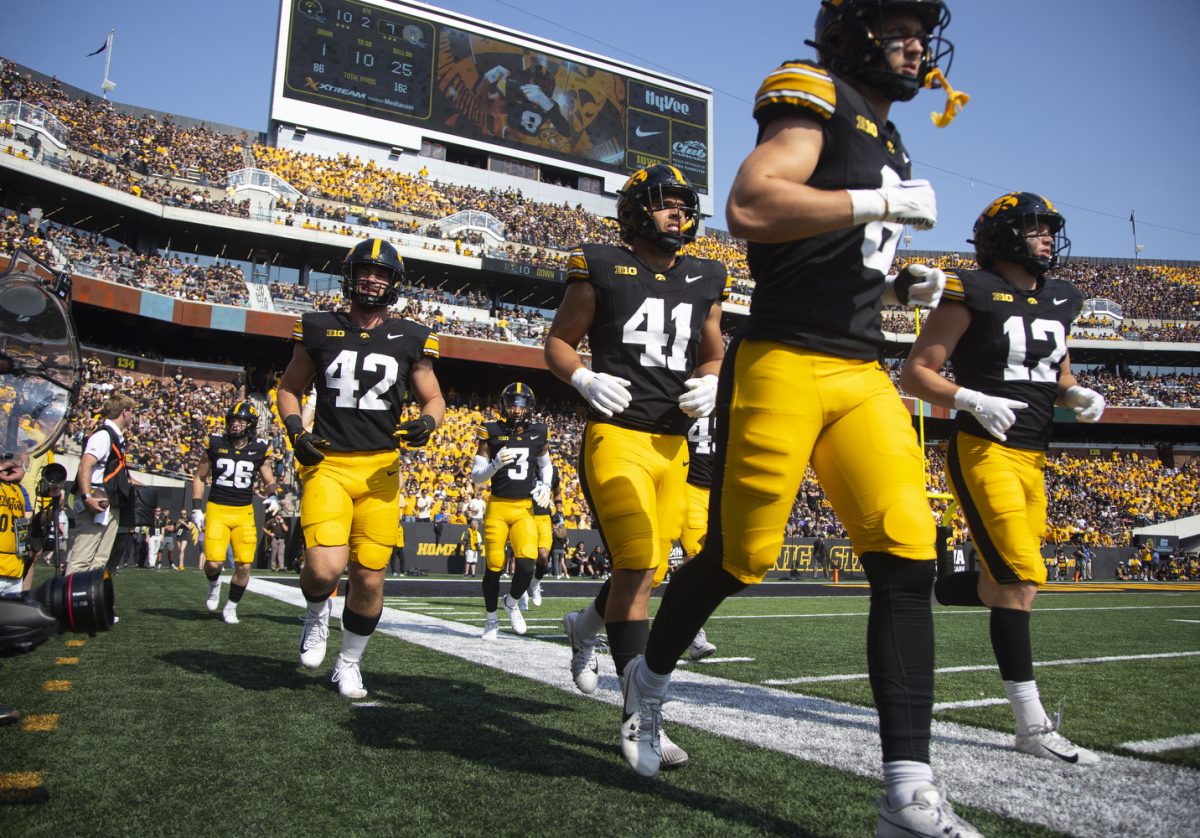 Hawkeye players run along the sidelines during a football game between Washington and Iowa at Kinnick Stadium in Iowa City on Saturday, Oct. 12, 2024. The Hawkeyes defeated the Huskies 40-16. (Emma Calabro/The Daily Iowan)