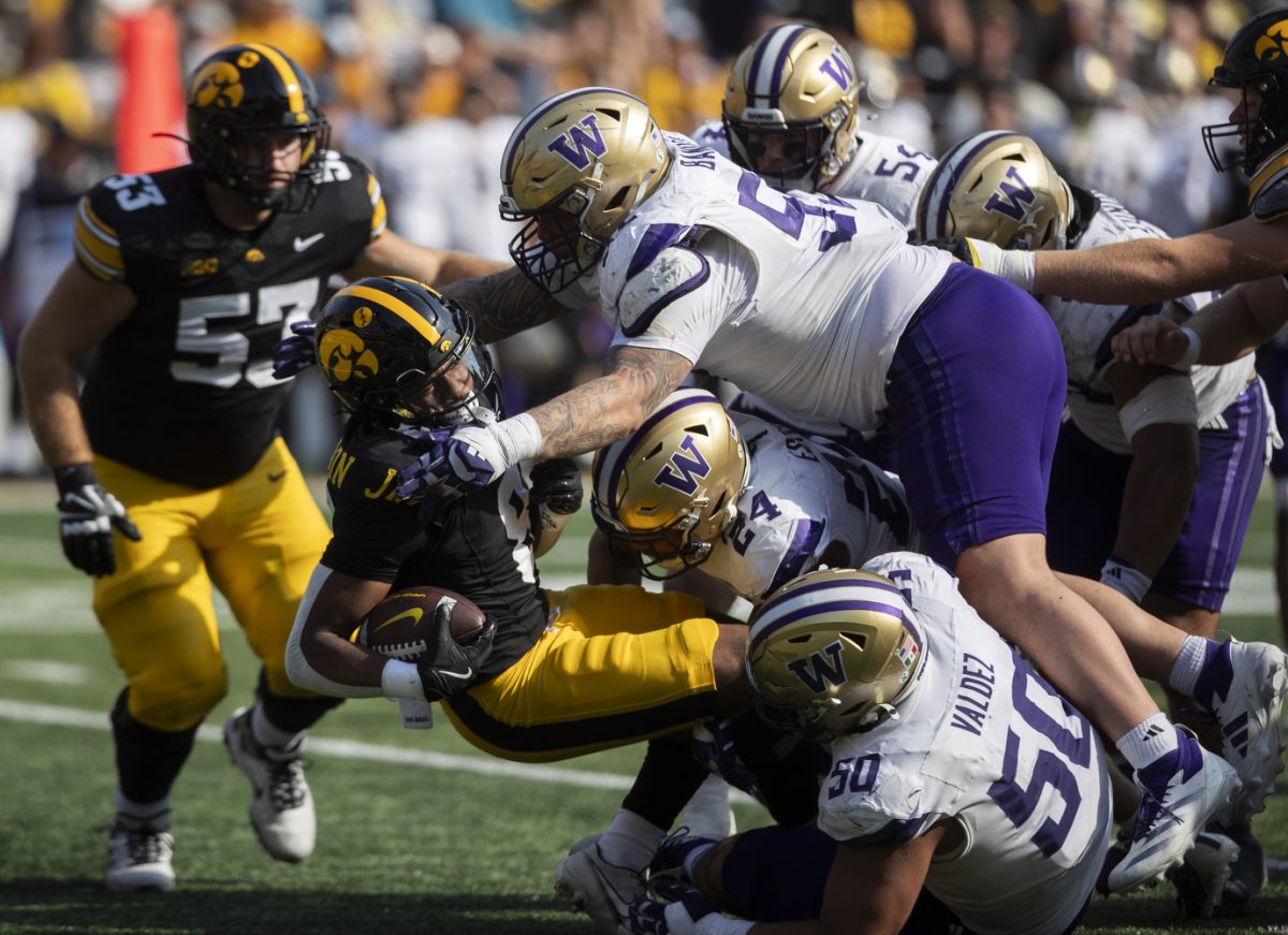 Iowa wide receiver Seth Anderson is tackled by Washington defensive lineman Jacob Bandes during a football game between Iowa and Washington at Kinnick Stadium in Iowa City on  Saturday, Oct. 12, 2024.  The Hawkeyes defeated the Huskies 40-16.