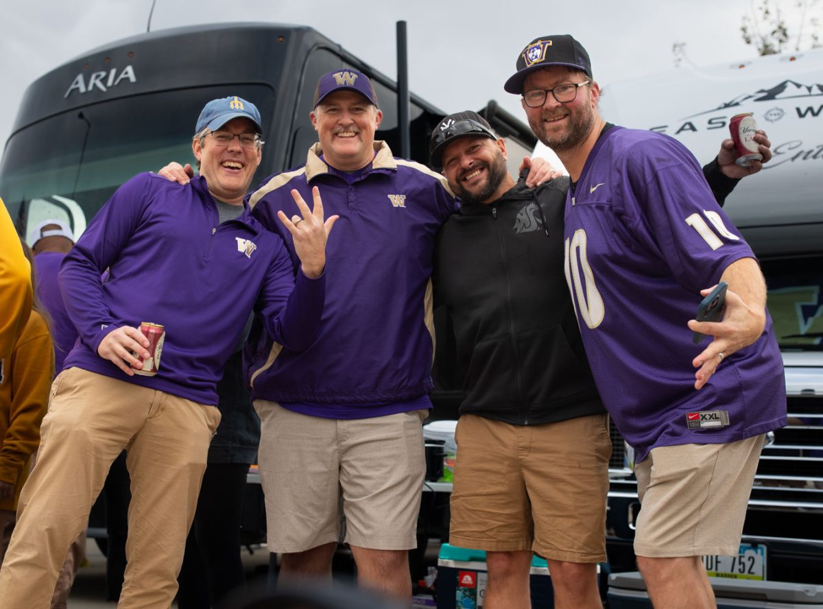 Washington fans pose for a picture at a tailgate before a football game between Washington and Iowa at Kinnick Stadium in Iowa City on Saturday, Oct. 12, 2024. The Hawkeyes defeated the Huskies 40-16. (Emma Calabro/The Daily Iowan)