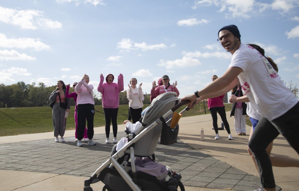 Nir Ben-Shlomo runs the 5K with baby Ori during the Zeta Tau Alpha 25th 5K run for Breast Cancer Education and Awareness in Iowa City on Oct. 13, 2024. The sorority raised almost $20,000 and had over 100 participants.