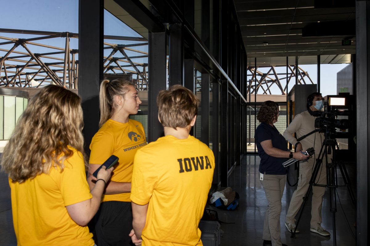 Women’s wrestlers wait in line to answer questions during the second annual Iowa women’s wrestling media day at the Goschke Family Wrestling Training Center in Iowa City, on Oct. 15, 2024. 