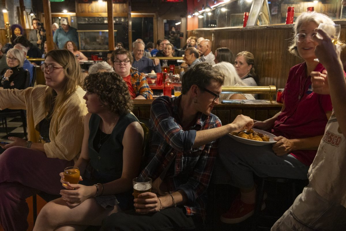 Local democrats watch a debate between Christina Bohannan and Mariannette Miller-Meeks at Sanctuary Pub in Iowa City on Monday, Oct. 21, 2024. The watch party drew a packed crowd as eager voters listened to candidates for Iowa's 1st congressional district.