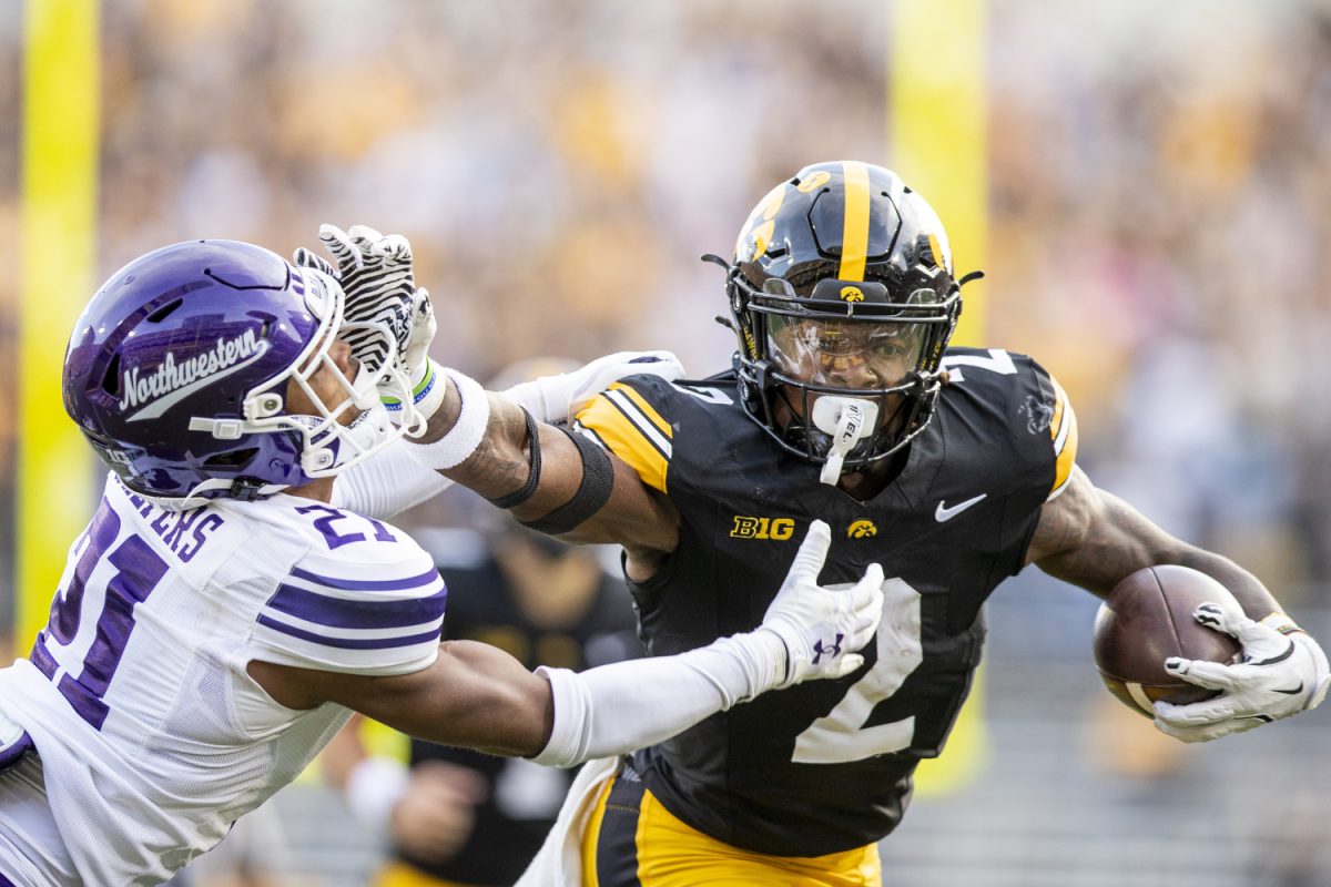 Iowa running back Kaleb Johnson stiff arms Northwestern defensive back Damon Walters before running into the endzone during a football game between Iowa and Northwestern at Kinnick Stadium on Saturday, Oct. 26, 2024. Following the first half the Hawkeyes lead the Wildcats, 12-7. (Cody Blissett/The Daily Iowan)