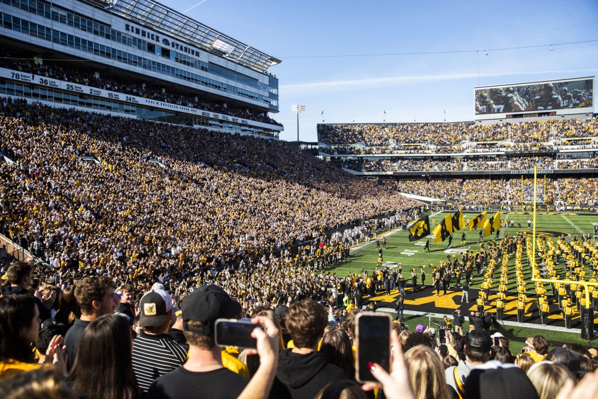 Iowa fans watch players swarm onto the field before a football game between Iowa and Northwestern at Kinnick Stadium on Saturday, Oct. 26, 2024. The Hawkeyes defeated the Wildcats 40-14.