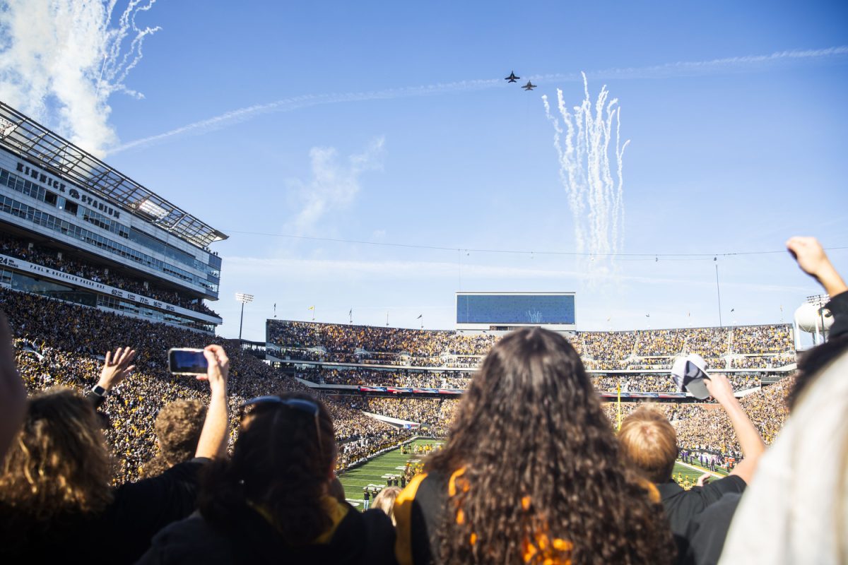 Fans watch a flyover before a fooball game between Iowa and Northwestern at Kinnick Stadium on Saturday, Oct. 26, 2024. The Hawkeyes defeated the Wildcats 40-14.