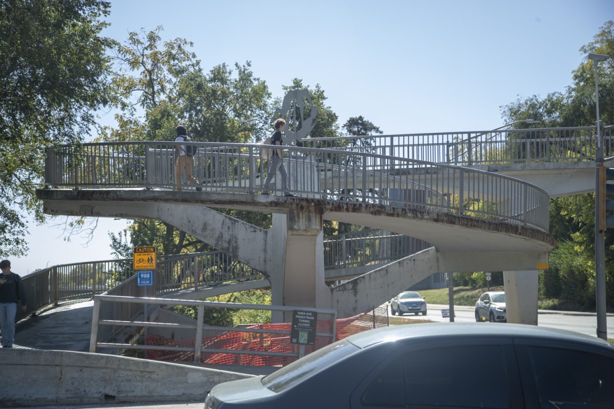 Pedestrians walk across the Iowa Ave pedestrian bridge in Iowa City on Monday, Oct. 7, 2024. Due to cracks and deterioration, the pedestrian bridge will be closed for repairs in the summer of 2025.