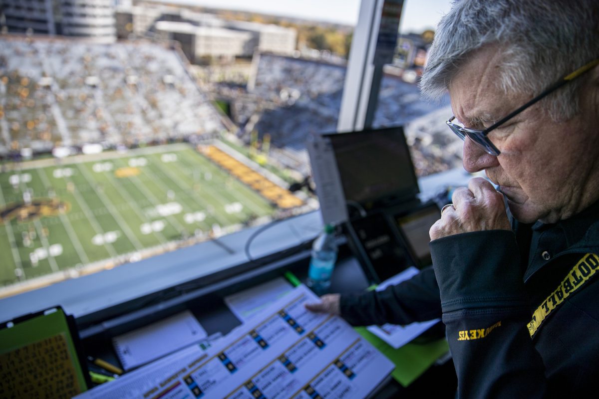 Hawkeye Radio Network’s Gary Dolphin looks at materials before a football game between Iowa and Northwestern at Kinnick Stadium on Saturday, Oct. 26, 2024. The Hawkeyes defeated the Wildcats, 40-14.