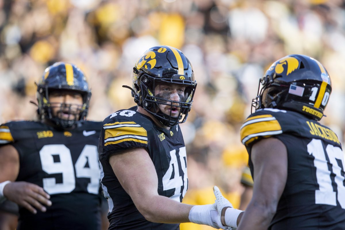 Iowa defensive lineman Max Llewellyn shakes hands with Iowa linebacker Nick Jackson after forcing a safety during a football game between Iowa and Northwestern at Kinnick Stadium on Saturday, Oct. 26, 2024. The Hawkeyes defeated the Wildcats, 40-14. (Cody Blissett/The Daily Iowan)