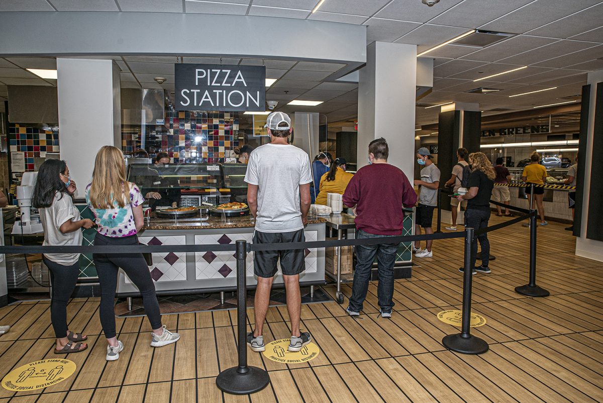 A Burge Marketplace worker serves a line of students on Monday, Aug. 26, 2020. 