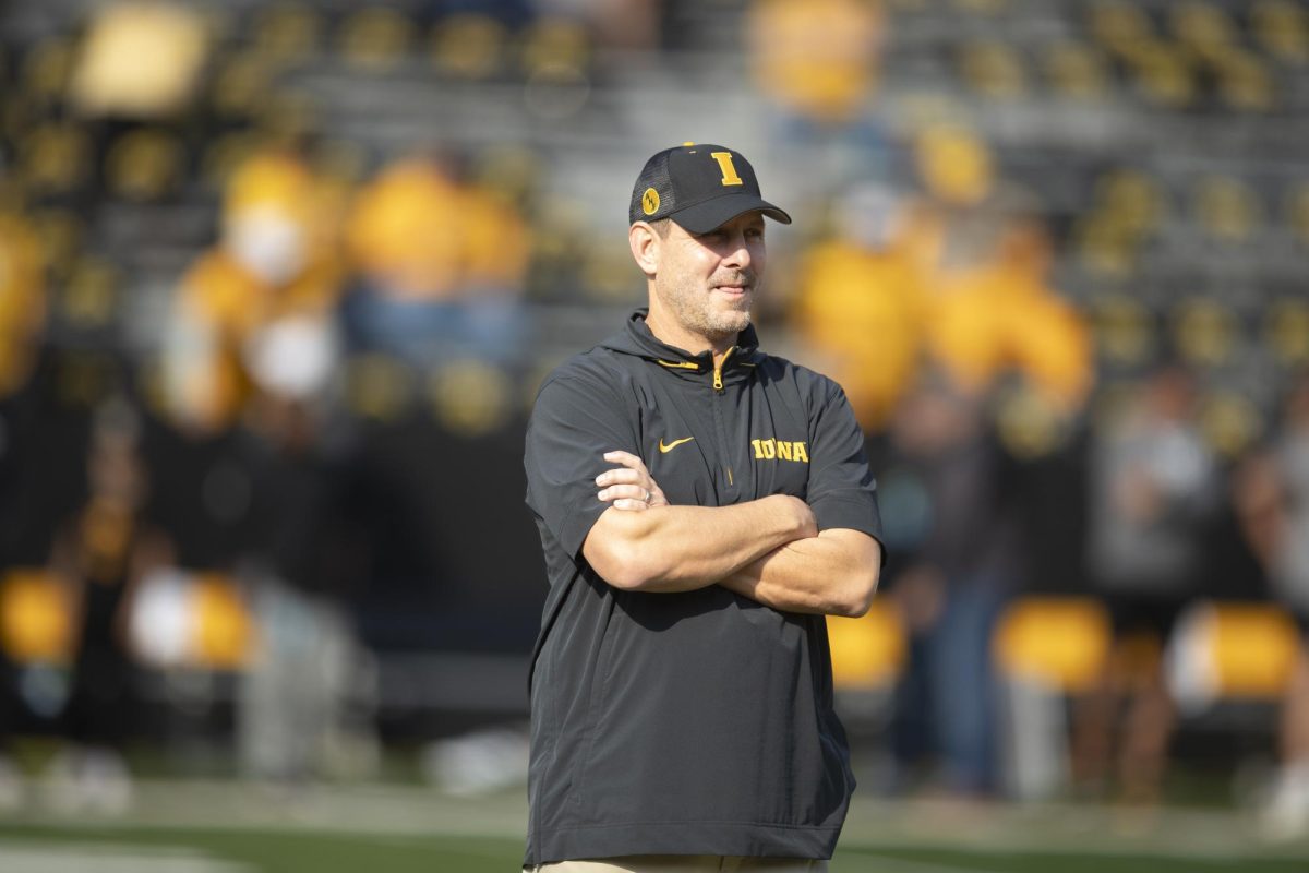 Iowa offensive coordinator Tim Lester watches players warm up before a football game between Washington and Iowa at Kinnick Stadium in Iowa City on Oct. 12. The Hawkeyes defeated the Huskies, 40-16. 