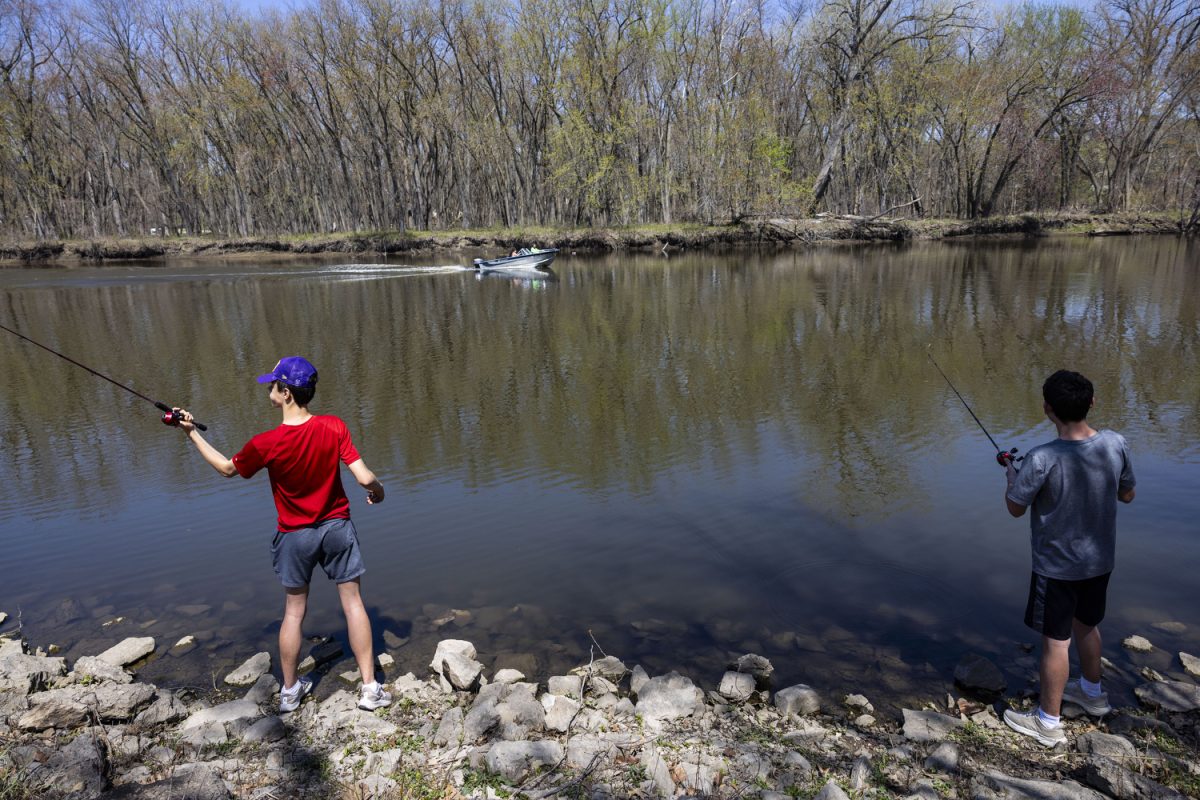 Will Carey, 15, and David Randall, 14, fish on Iowa River at City Park in Iowa City, Iowa, on Sunday, April 14, 2024. Numerous families, groups, and friends congregated in the park to enjoy the sun. Temperatures in Iowa City reached up to 86 degrees.