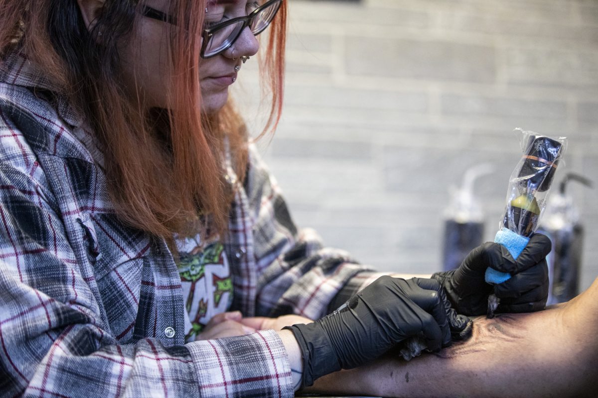 Nikkia Evans tattoos a client at Neon Dragon Tattoo & Body Piercing in Cedar Rapids on Oct. 16. Evans has been an apprentice at Neon Dragon for a little over a year.