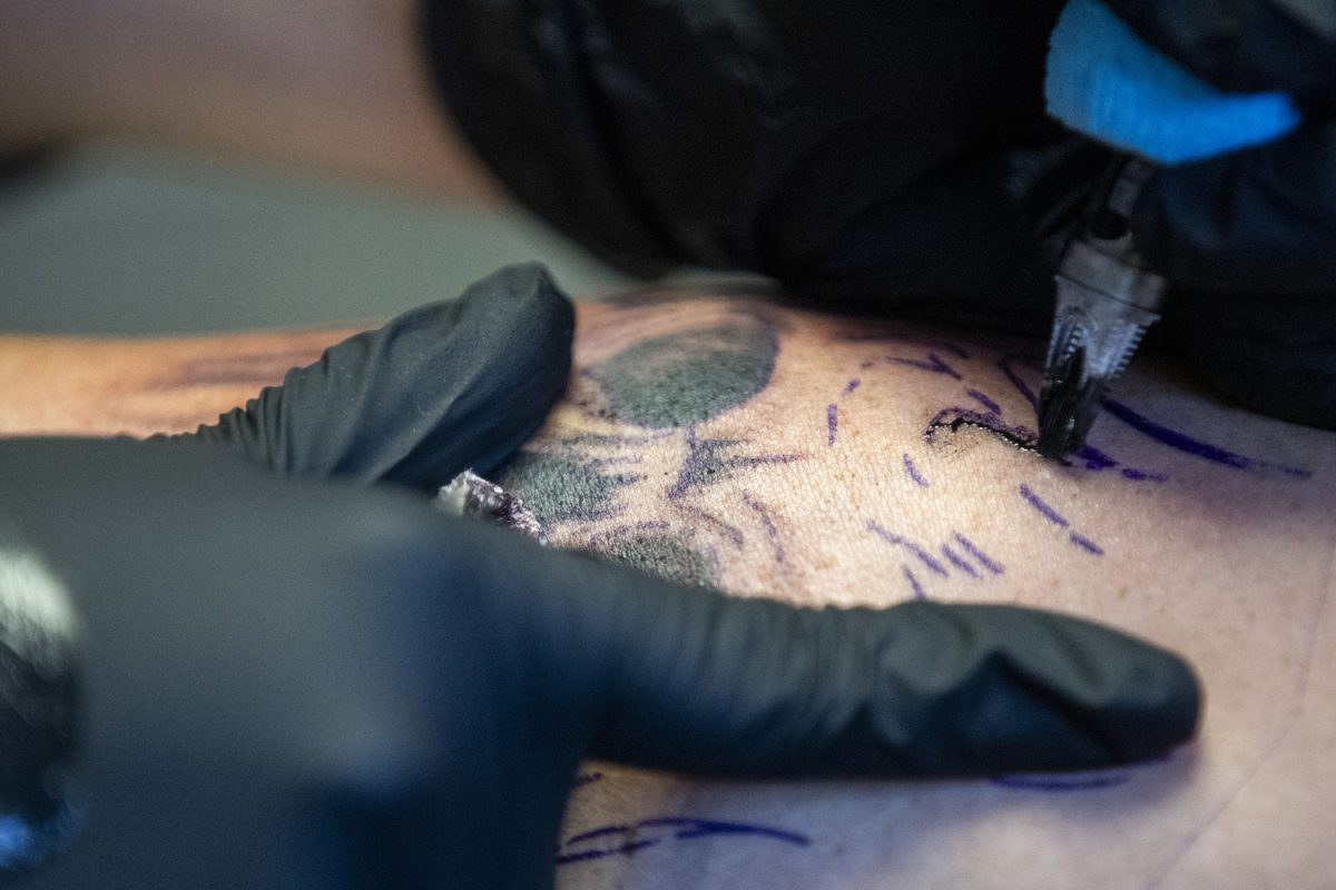 Nikkia Evans tattoos a client at Neon Dragon Tattoo & Body Piercing in Cedar Rapids on Oct. 16, 2024. Evans has been an apprentice at Neon Dragon for a little over a year.
