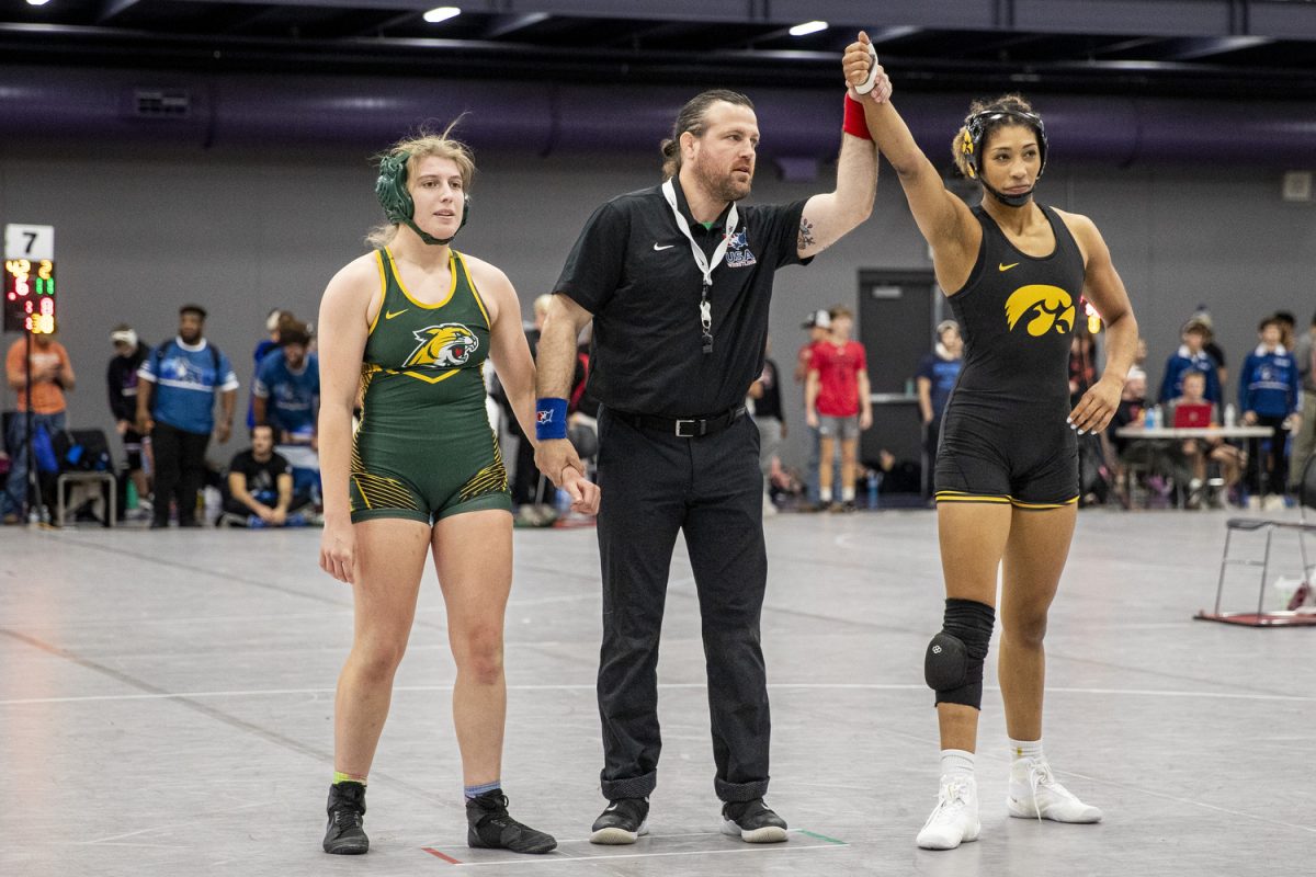 An official holds up Iowa 160-pound Kennedy Blades’ arm after her win against Northerner Michigan Sophia Bassino during the Luther Hill Open Titles at the Blake Field House in Indianola, Iowa, on Saturday, Nov. 2, 2024. Iowa ended the tournament with six champions and an overall record of 58-17. (Cody Blissett/The Daily Iowan)