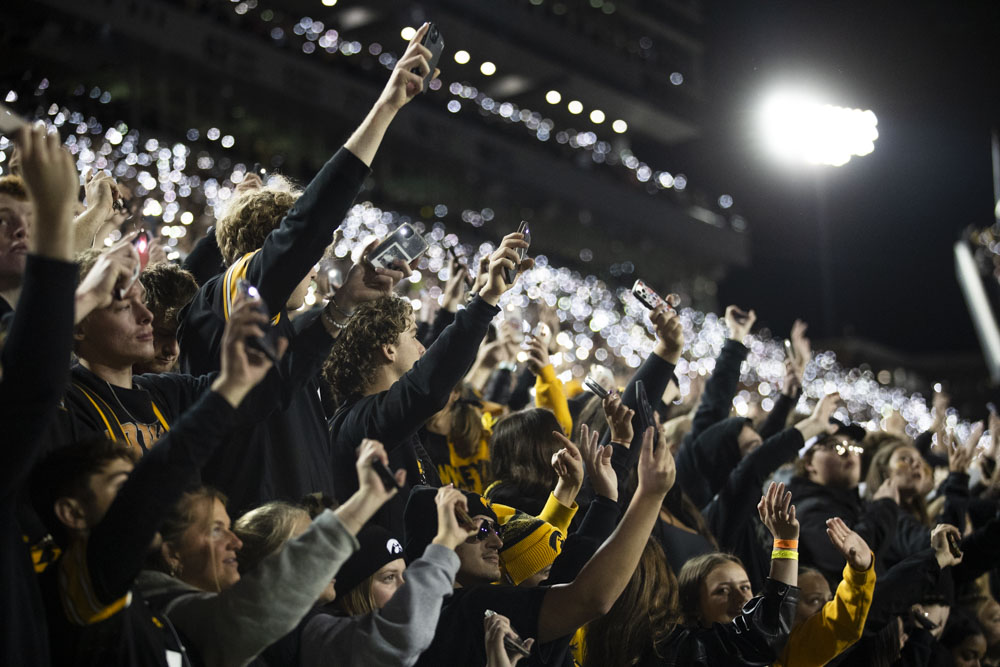 Fans use flashlights during the Hawkeye Wave after the first quarter of a football game between Iowa and Wisconsin at Kinnick Stadium on Saturday, Nov. 2, 2024. The Hawkeyes defeated the Badgers 42-10.