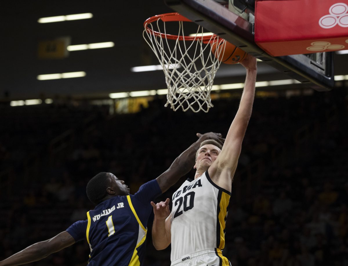 Iowa forward Payton Sandfort goes up for a dunk against TA&MC guard Scooter Williams Jr. during an Iowa mens basketball game against Texas A&M Commerce at Carver-Hawkeye Arena in Iowa City on Monday, Nov 4, 2024. The Hawkeyes shot 20 free throws throughout the game on Monday. The Hawkeyes defeated the Lions 89-67.