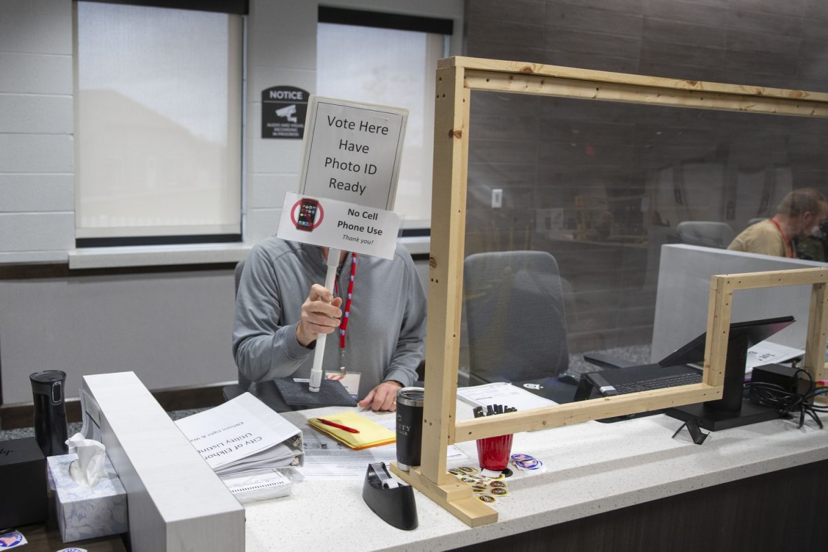 A volunteer at Elkhorn City Hall holds up an informational sign on Election Day in Elkhorn, Wisconsin, on Tuesday, Nov. 5, 2024. As of 2023, Elkhorn has a population of 10,230 people. Elkhorn City Hall has been the polling location for City of Elkhorn residents as of 2022, accommodating all size elections. Polls in the city hall opened at 7:00 a.m. and close at 8:00 p.m.