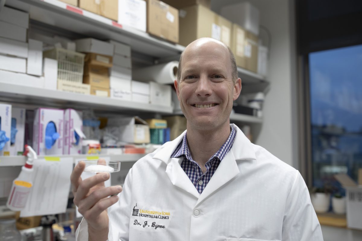 Dr. James Byrne poses for a portrait with his cancer foam in his lab on Nov. 14, 2024. Bryne is a University of Iowa assistant professor using foam made of new, biocompatible materials to improve the effectiveness of cancer treatments.