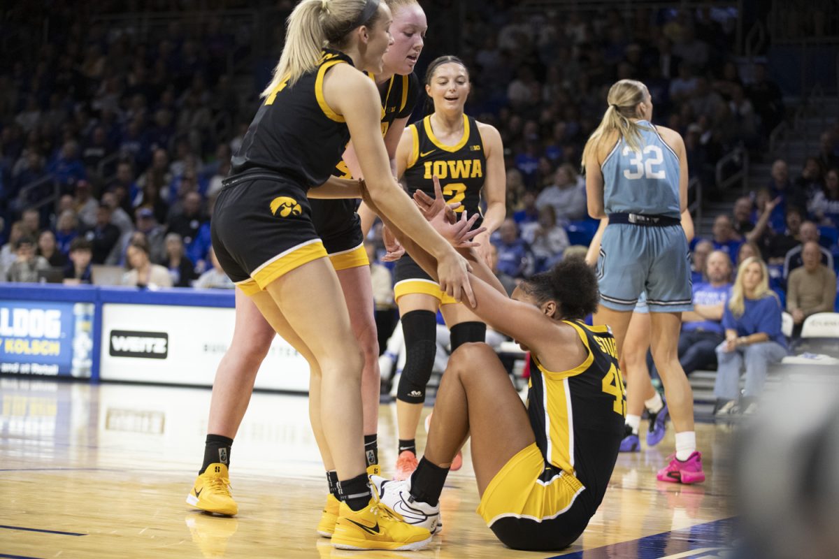 Iowa players help Hannah Stuelke get up during an Iowa women’s basketball game against Drake at the Knapp Center on Nov. 17 in Des Moines. The Hawkeyes defeated the Bulldogs, 86-73, with standout performances on both teams.