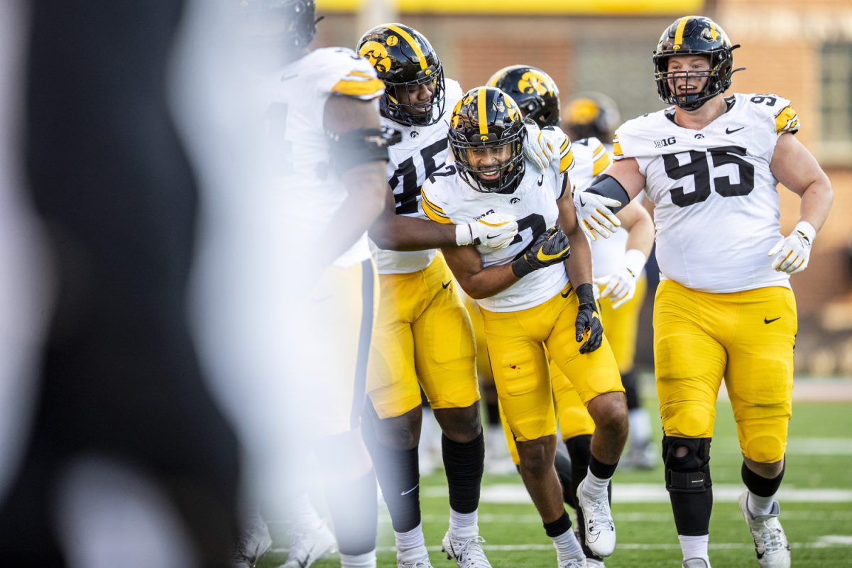 Players embrace Iowa defensive back TJ Hall after his interception during a football game between Iowa and Maryland at SECU Stadium in College Park, Md. on Saturday, Nov. 23, 2024. The Hawkeyes defeated the Terrapins 29-13.