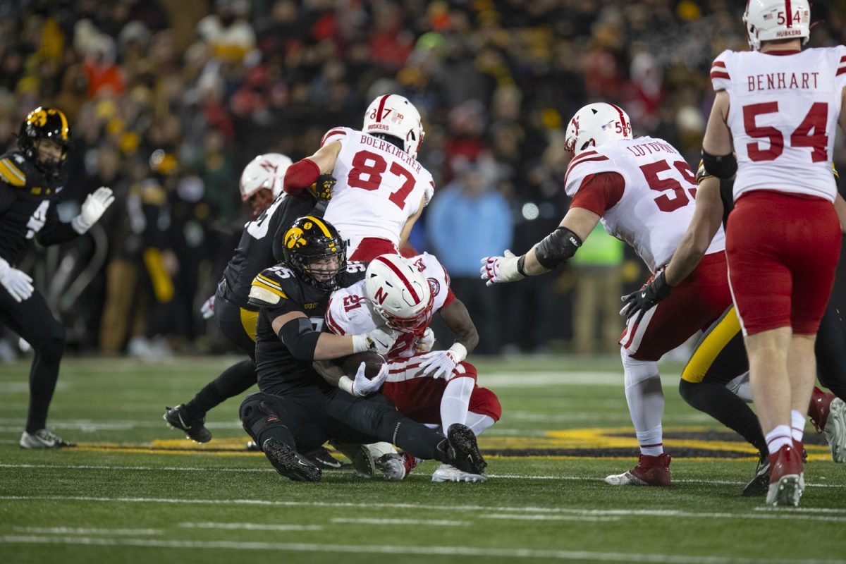 Iowa defensive lineman Aaron Graves tackles Nebraska running back Emmett Johnson during a football game between Iowa and Nebraska at Kinnick Stadium in Iowa City on Friday, Nov. 29, 2024. Iowa defeated Nebraska, 13-10.