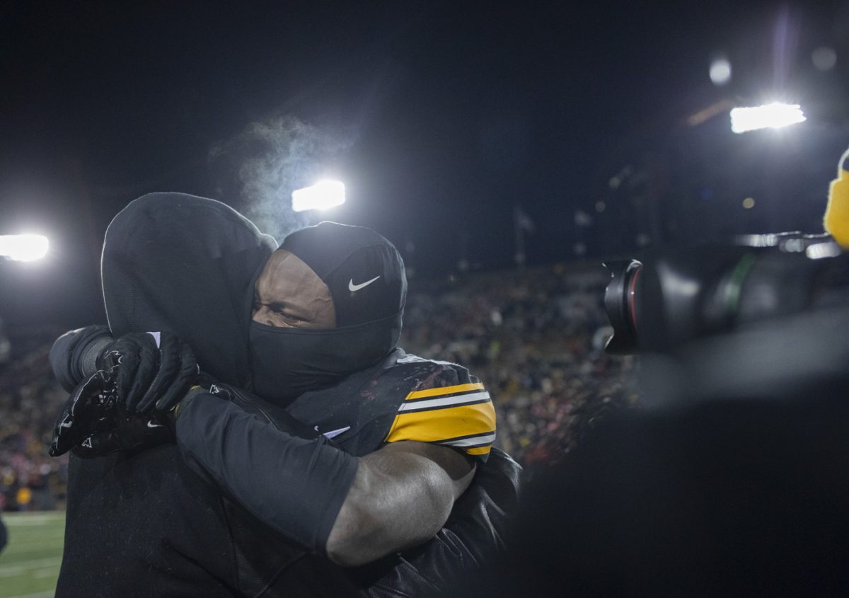 Iowa running back Kaleb Johnson embraces a coach after winning a football game between Iowa and Nebraska at Kinnick Stadium in Iowa City on Friday, Nov. 29, 2024. Iowa defeated Nebraska, 13-10.