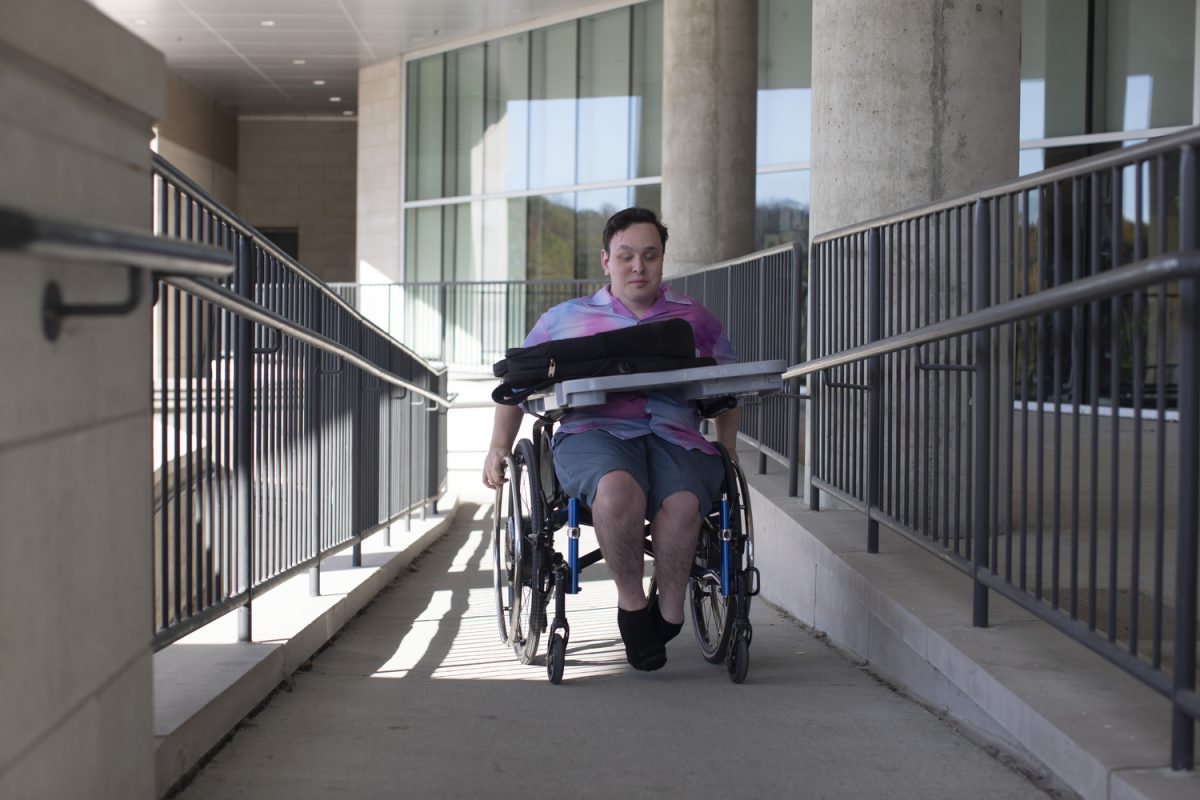 Kristian Marchand, a freshman at the University of Iowa, travels to their dorm on Friday, Oct. 25, 2024. Marchand recently started a petition to make Macbride hall more accessible for those with physical disabilities.