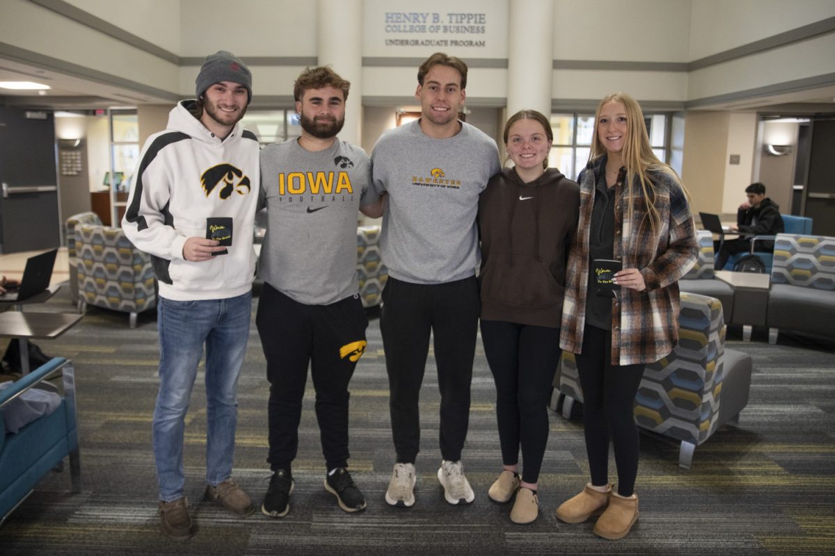 Jared Weeks, Jacob Summer, Jackson Glenn, Natalie Noonan, and Jaelyn Boley pose with their Koozies for a Cause in Tippie College of Business in Iowa City on Wednesday, Nov. 20, 2024. The $5 Wave To The Brave beer koozies are donated to the Stead Family Children’s Hospital. The five students worked together in Bob Walker’s entrepreneurial finance class to launch the startup project.