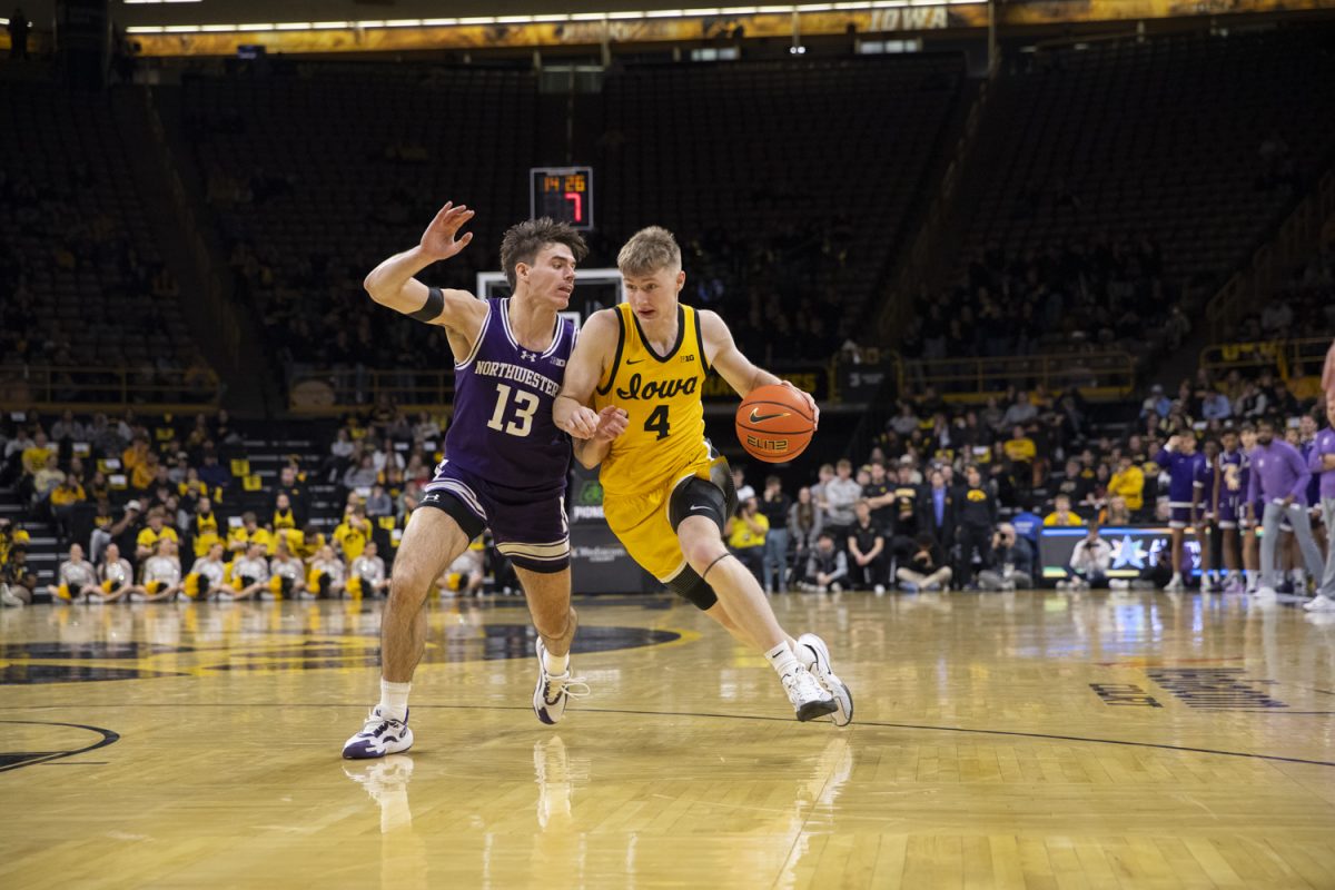 Josh Dix dribbles past Brooks Barnhizer during an Iowa basketball game against the Northwestern Wildcats on December 3rd at Carver-Hawkeye Arena in Iowa City, Iowa. This was the first Big-Ten matchup for the Hawkeyes, who came out with a last second win over the Wildcats, 80-79.