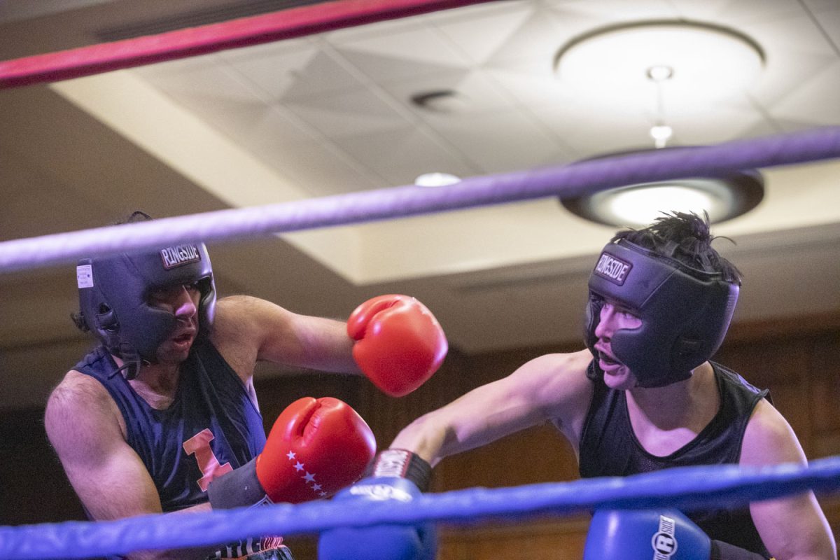 Illinois’ Ali Al Chalabi boxes Iowa’s Gabriel Frausto  during Fall Brawl, hosted by Iowa Boxing Club, at the Iowa Memorial Union at the University of Iowa on Saturday, Dec. 7, 2024. Numerous schools including Iowa State, Wisconsin, and Illinois, as well as other boxing organizations fought in 11 bouts.