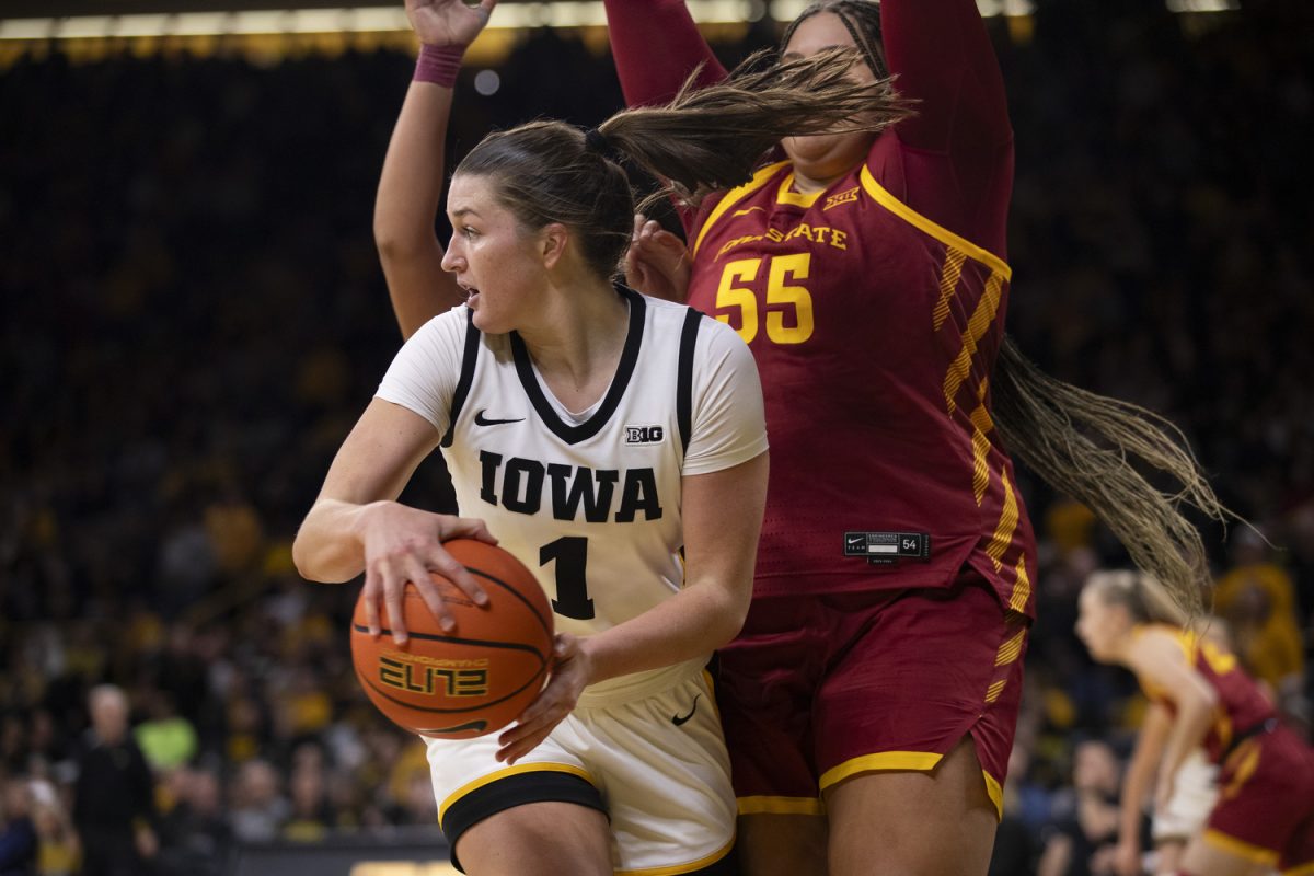 Taylor Stremlow looks to pass around Audi Crooks during the Iowa Corn Cy-Hawk Series, a basketball game between Iowa and Iowa State at Carver-Hawkeye Arena in Iowa City, Iowa on Wednesday, Dec. 11, 2024. The Hawkeyes defeated the Cyclones 75-69.