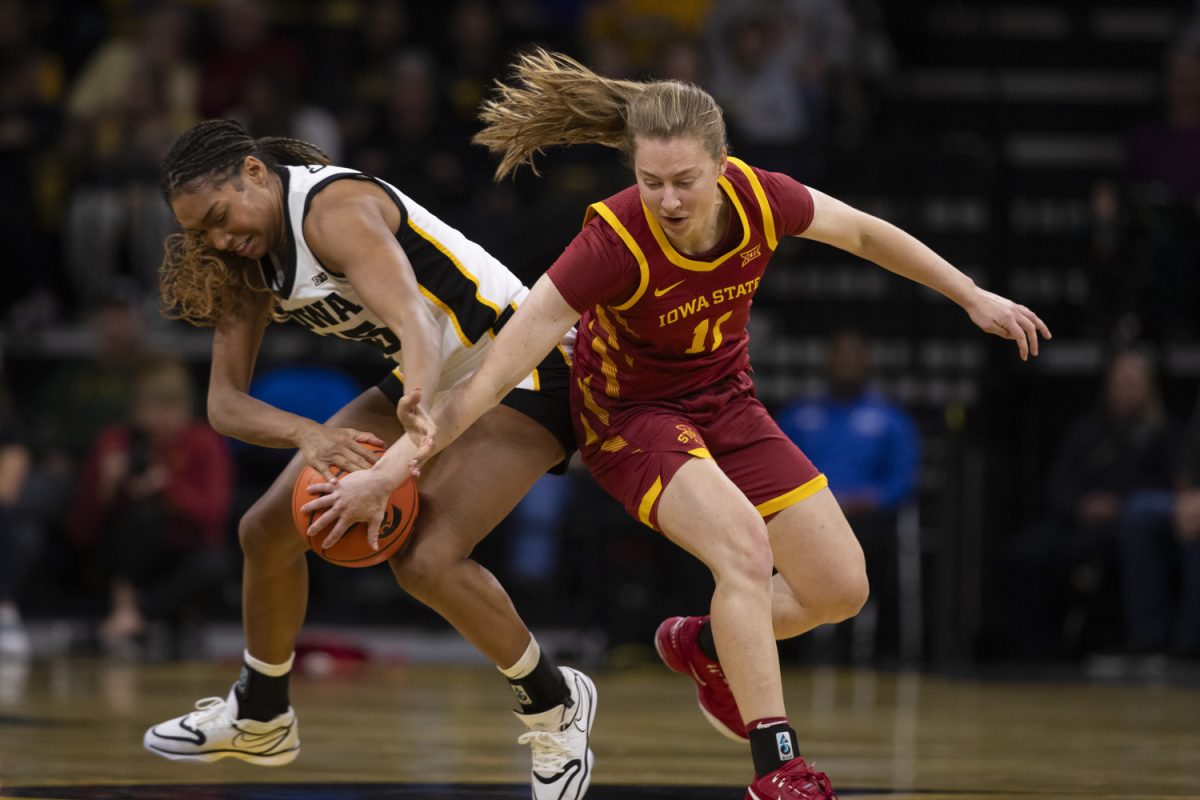 Emily Ryan and Hannah Stuelke fight for the ball during the Iowa Corn Cy-Hawk Series, a basketball game between Iowa and Iowa State at Carver-Hawkeye Arena in Iowa City, Iowa on Wednesday, Dec. 11, 2024. The Hawkeyes defeated the Cyclones 75-69.