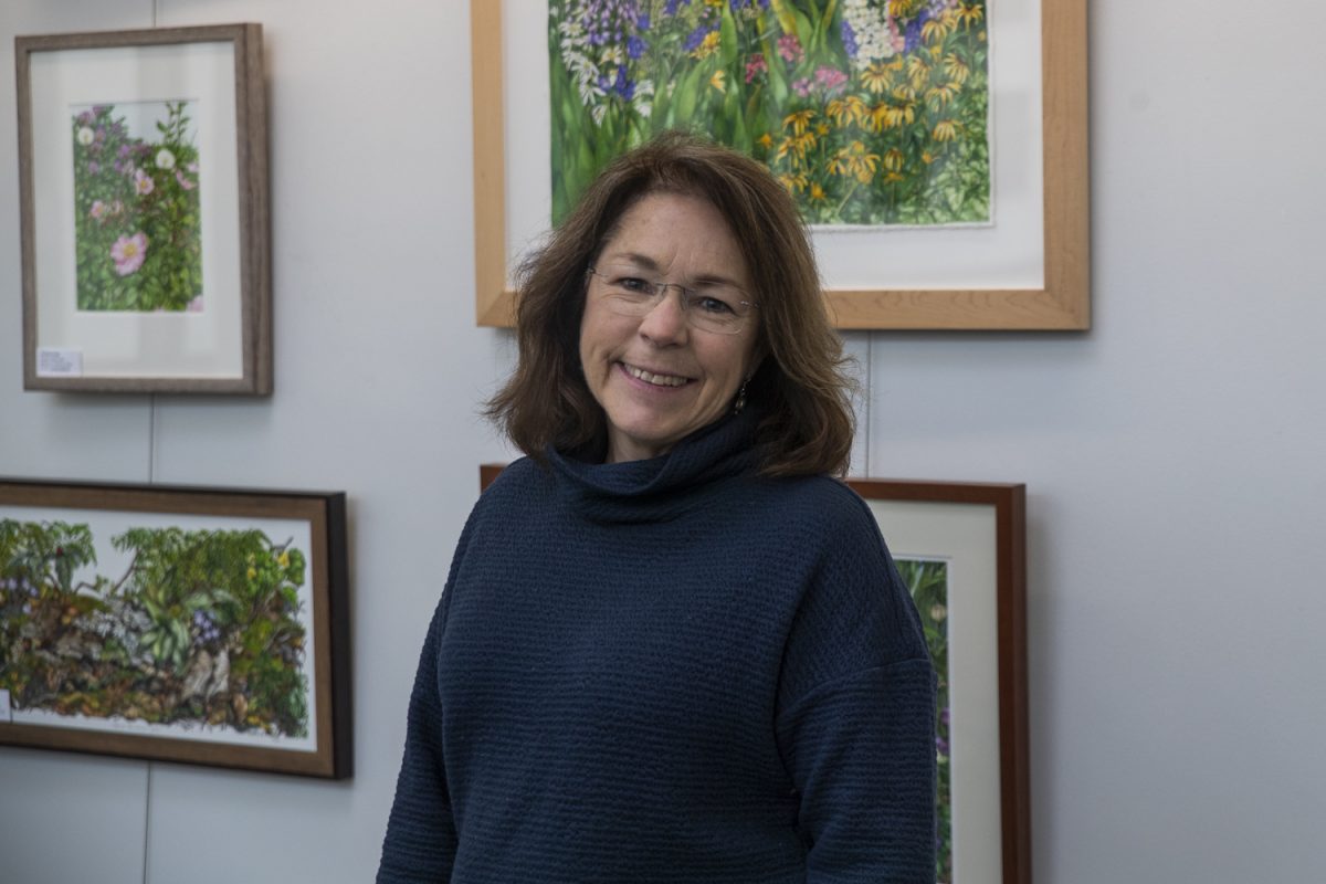 Barbara Weets poses for a portrait in front of her art at the John Pappajohn Bio-Medical Discovery Building in Iowa City on Thursday, Dec. 12, 2024. Notecards of Weets’ art will be for sale at the Holiday Market at the Robert A. Lee Recreation Center in Iowa City on Saturday, Dec. 16, 2024 from 8 a.m. to 1 p.m.  