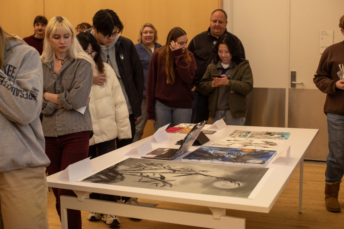 Attendees look at student work during an exhibit of ink art at the Stanley Museum of Art on Thursday, Dec. 12, 2024. Students in Brushwork in Chinese Art, a class taught by Assistant Professor Amy Huang, led presentations and showcased their work from the semester.