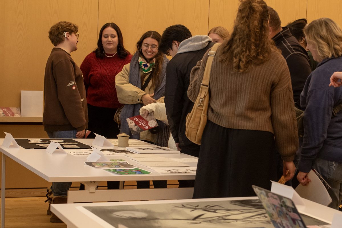 Attendees look at student work during an exhibit of ink art at the Stanley Museum of Art on Thursday, Dec. 12, 2024. Students in Brushwork in Chinese Art, a class taught by Assistant Professor Amy Huang, led presentations and showcased their work from the semester.