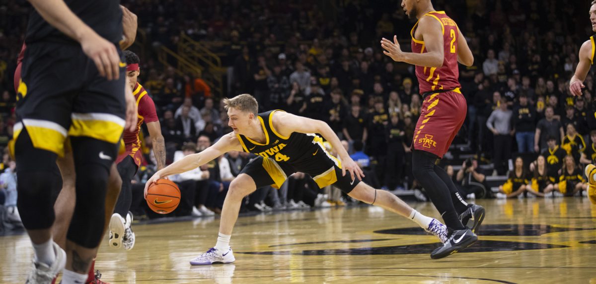 Iowa’s Josh Dix reaches to save the ball during a men’s basketball game between Iowa and Iowa State at Carver-Hawkeye Arena on Dec. 12, 2024. The Cyclones defeated the Hawkeyes, 89-80.