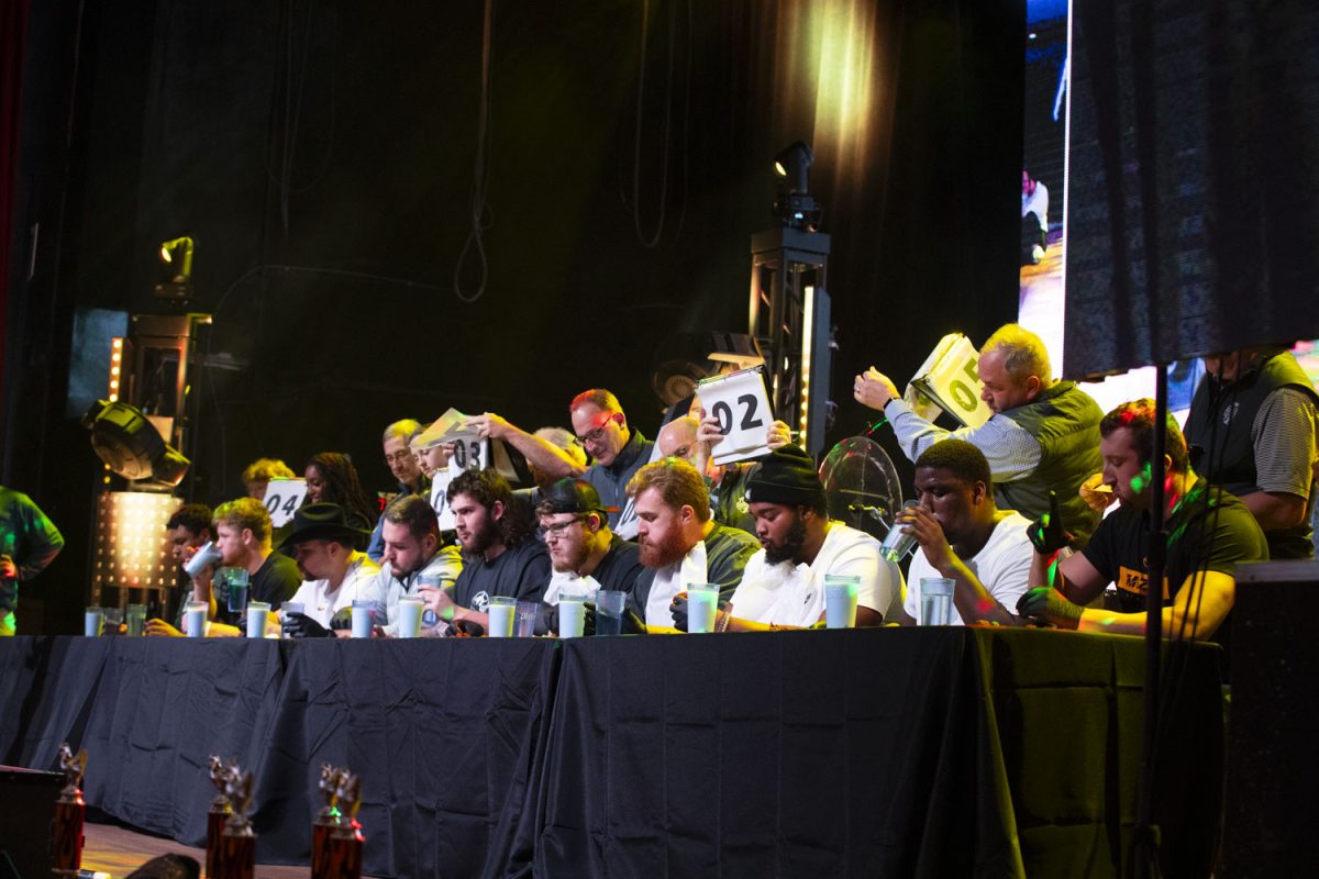 Offensive linemen from rival teams compete in a hot wing eating competition during a team welcome party at Category 10 in Nashville Tenn., on Friday, Dec. 27, 2024. The event had a chicken wing eating contest along with a finish-the-lyric challenge. 