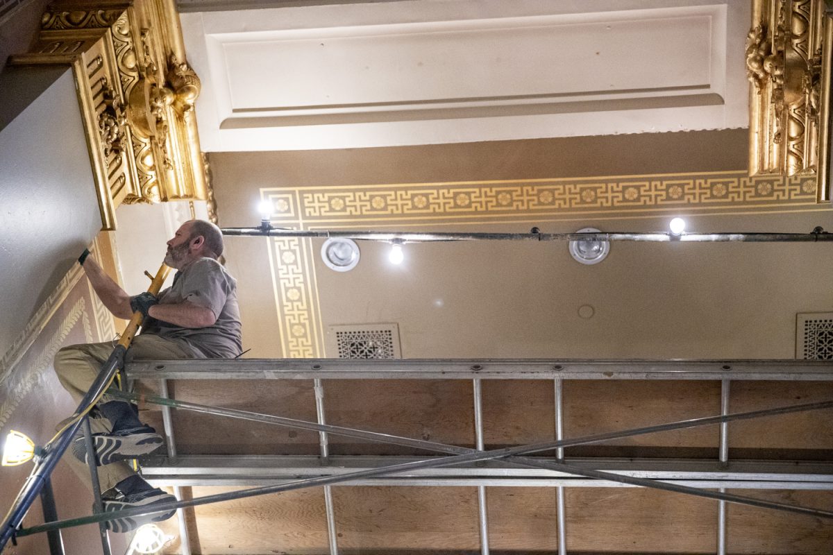 A worker makes off wallpaper during the State of the Judiciary address at the Iowa State Capitol in Des Moines on Wednesday, Jan. 15, 2025.
