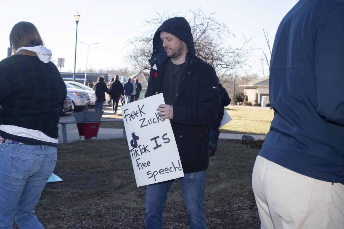 Attendees hold signs  during a singing circle and people’s march at the Coralville Public Library on Saturday, Jan. 18, 2024. The event was part of a string of nationwide People’s Marches in response to an upcoming Trump administration. Over 115 people attended the event, gathered in song, and marched around the area.