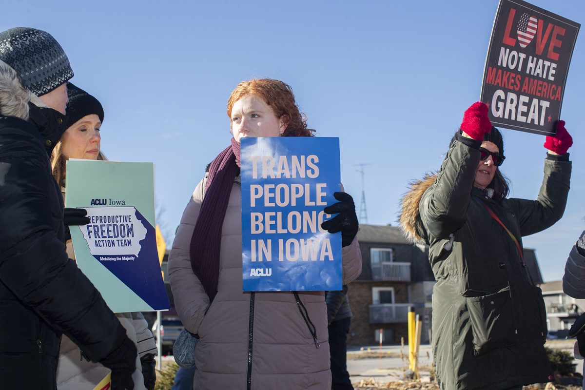 Attendees hold signs  during a singing circle and people’s march at the Coralville Public Library on Saturday, Jan. 18, 2024. The event was part of a string of nationwide People’s Marches in response to an upcoming Trump administration. Over 115 people attended the event, gathered in song, and marched around the area.