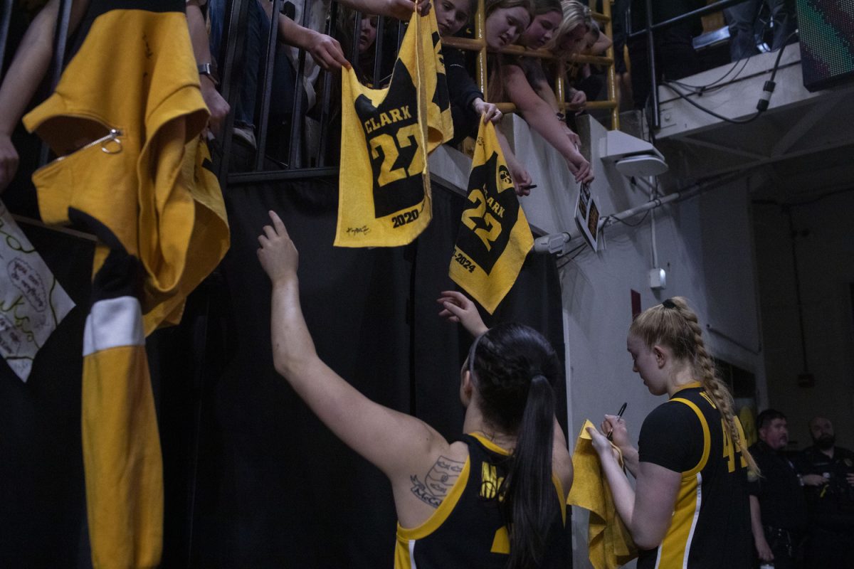 Iowa guard Taylor McCabe and Iowa forward Addison O'Grady sign towels after a women’s basketball game between Iowa and No. 4 Southern California at Carver-Hawkeye Arena on Sunday, Feb. 2, 2025. The Hawkeyes defeated the Trojans, 76-69. The sold-out game marked Iowa’s first Big Ten game against the Trojans and the retirement of the No. 22 for former Iowa guard Caitlin Clark.