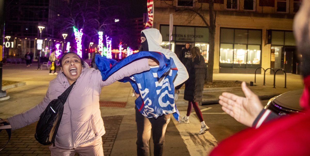 A protester tries to prevent conflict with a counter-protester during an immigration protest in downtown Iowa City on Friday, Feb. 3, 2025. Dozens of demonstrators danced, sang, chanted, and marched throughout the early evening. A handful of counter-protesters were in attendance. 
