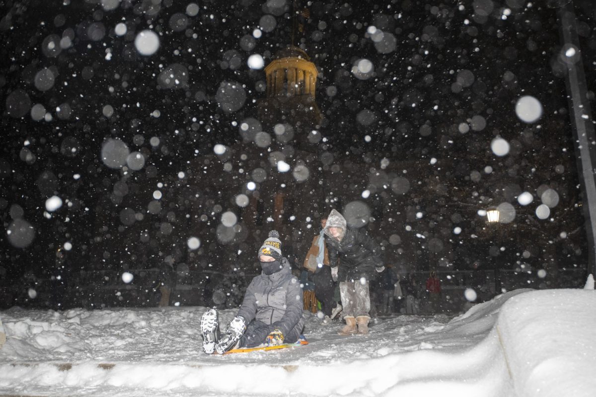 Students go sledding with makeshift sleds and skis during a snowstorm on the UI campus in Iowa City on Wednesday, Feb. 12, 2025. Multiple professors cancelled class after Iowa City reported an expected 6-9 inches of snow.