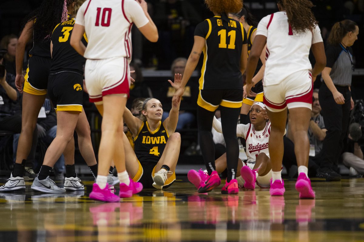 Iowa guard Kylie Feuerbach is helped up after a fall during a women's basketball game between Iowa and Wisconsin at Carver-Hawkeye Arena in Iowa City on Sunday, March. 2, 2025.